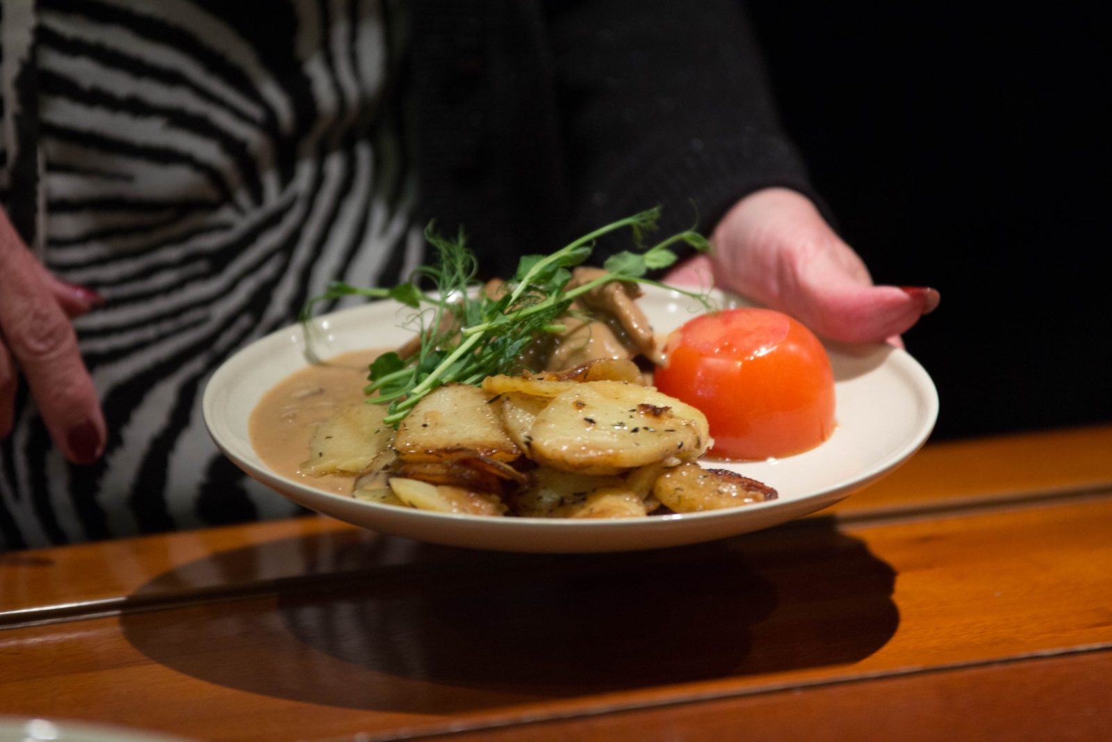 En tallrik med fläskfilé, svampsås och stekt potatis serveras